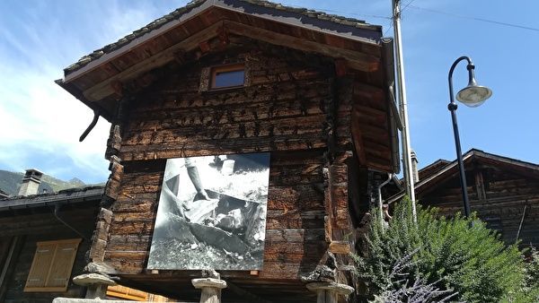 スイスの古いシャレーの壁に白黒の写真が展示されている。