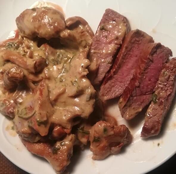 切り分けられたラム肉のステーキ。中身がほんのりピンク色にきのこクリームが添えられている。