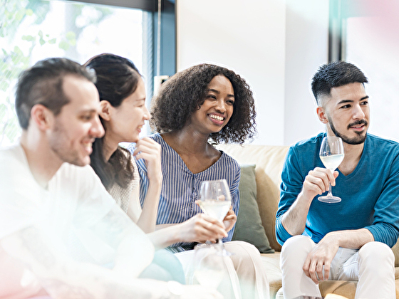 パーティーで楽しそうに雑談する4人の男女