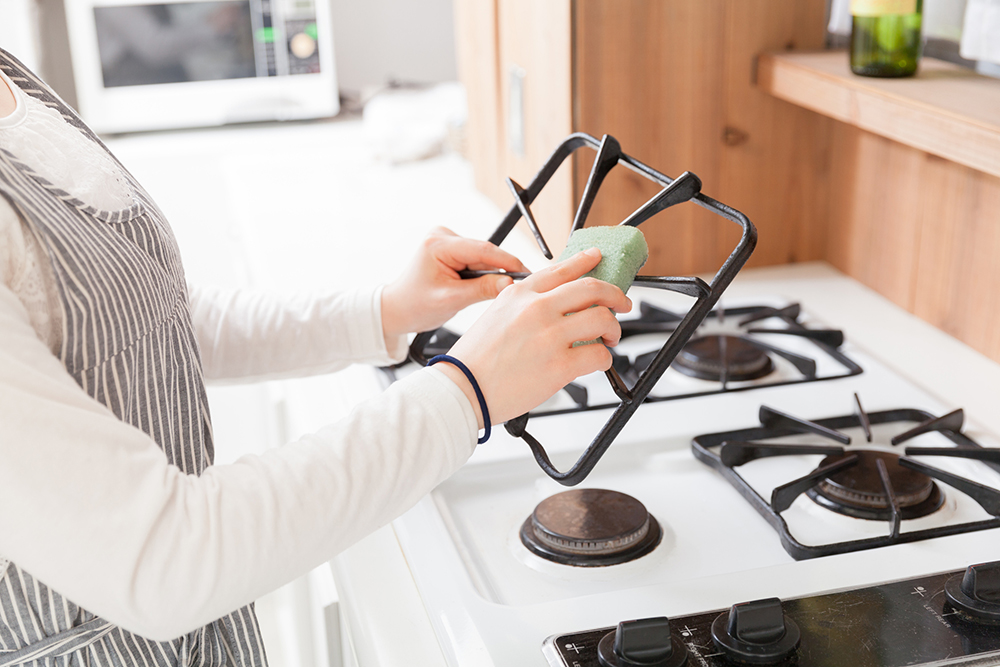 ガスコンロの掃除をする主婦