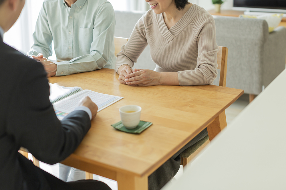 中年夫婦に説明するビジネスマン