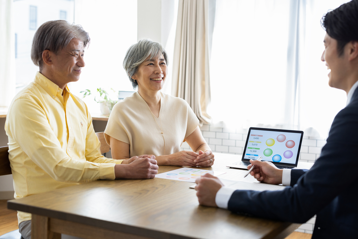 夫婦に説明をする営業スタッフ