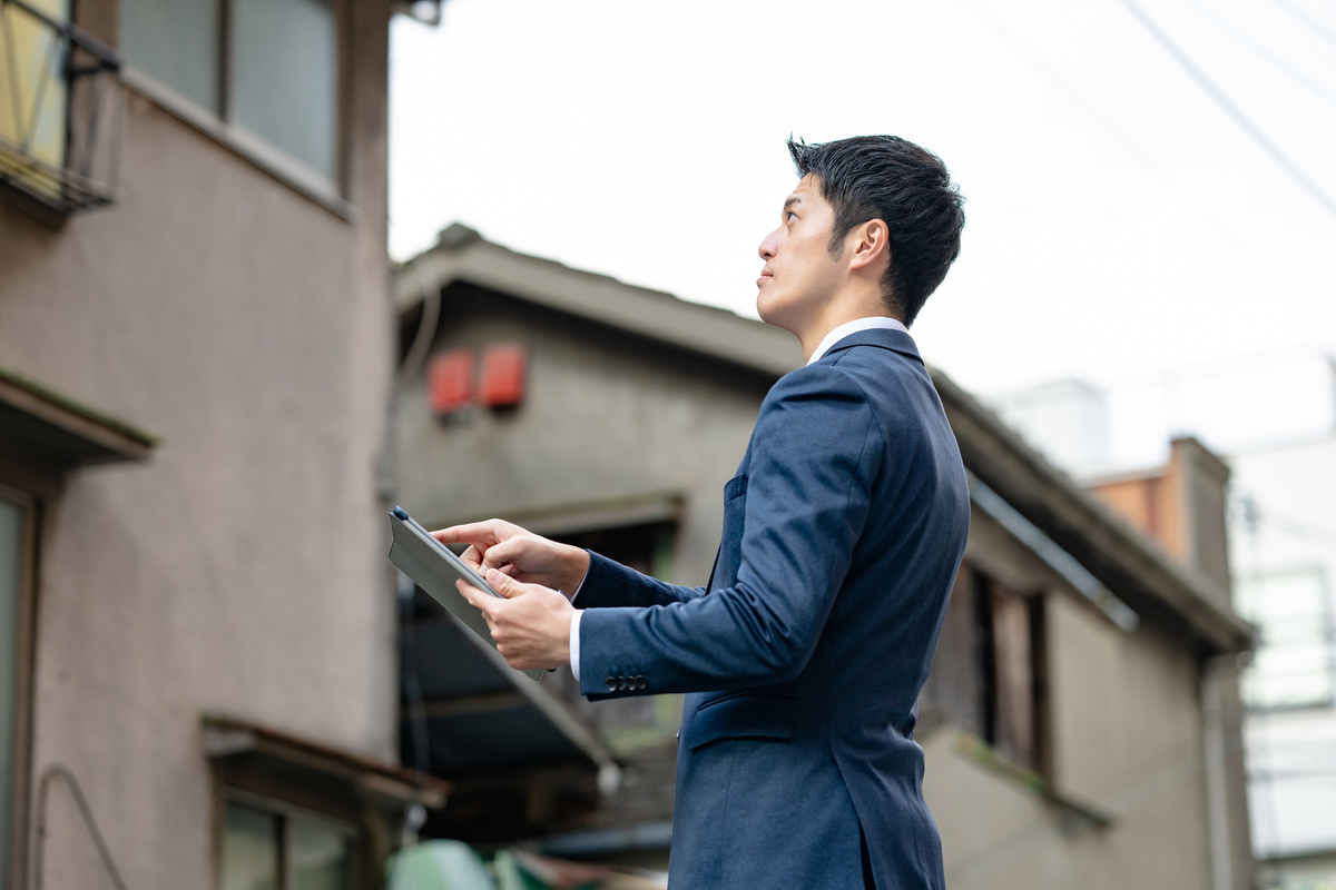 現地で査定を行う不動産会社の担当者のイメージ