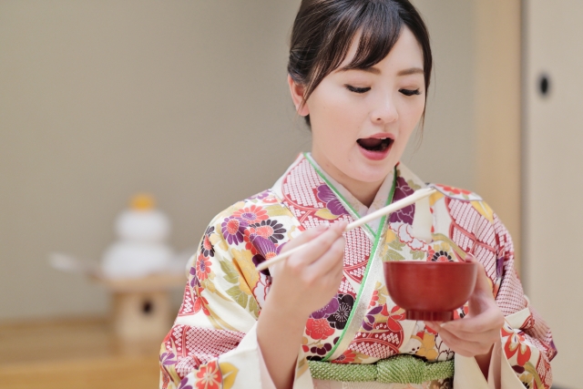 お雑煮を食べる着物姿の女性