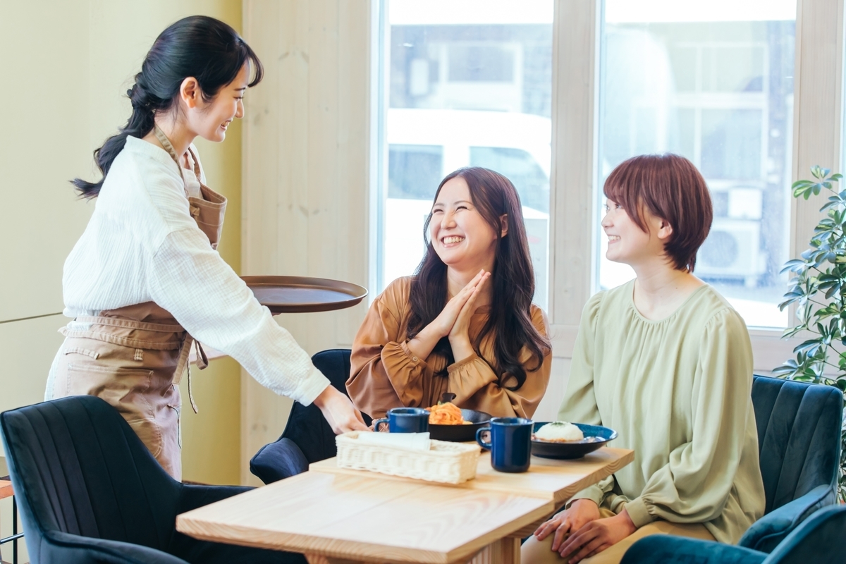 女子会でコーヒーを飲みながら楽しそうな会話をしている様子