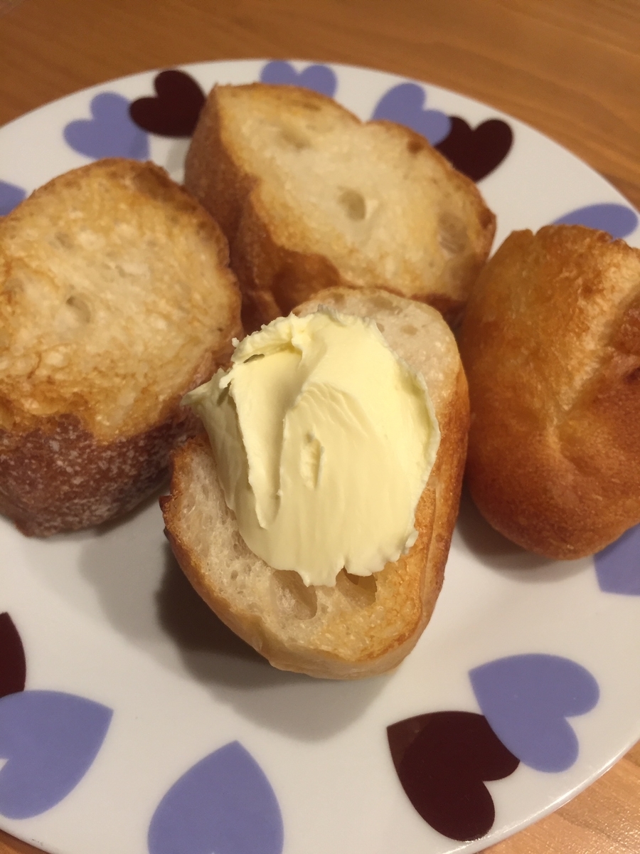 東京都町田市のアンテンドゥで購入したフランスパンを自宅でカットして焼いた後にバターを塗った写真
