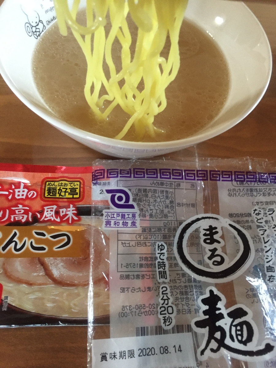 まる麺にとんこつスープを絡めて食べる様子を撮影した写真