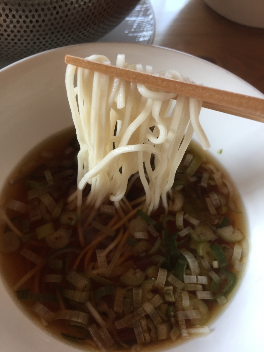 更科そばをそばつゆに絡めて食べる様子を撮影した写真