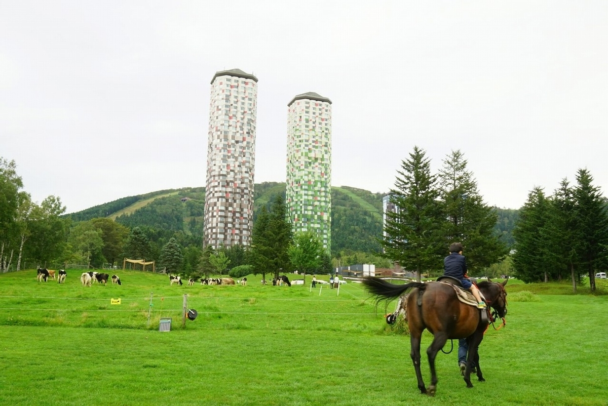 トマムザタワーを背景に馬に乗る子供