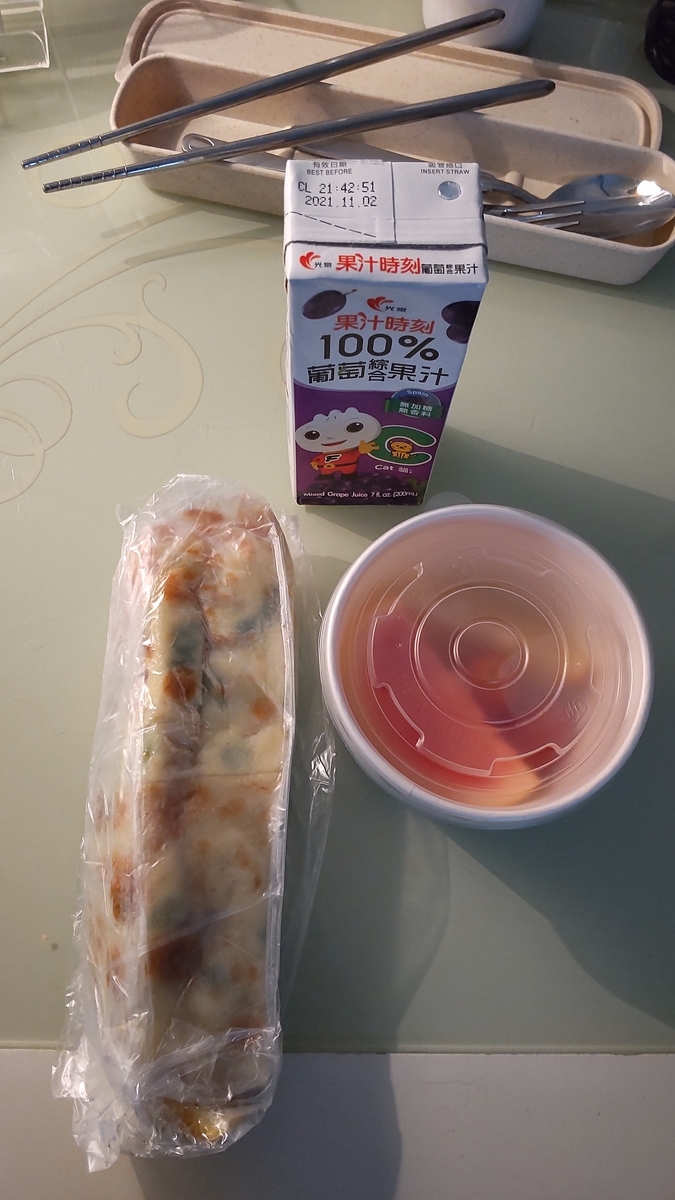 4日目の朝食。油條のクレープ、トマト、オレンジ、ぶどうジュース