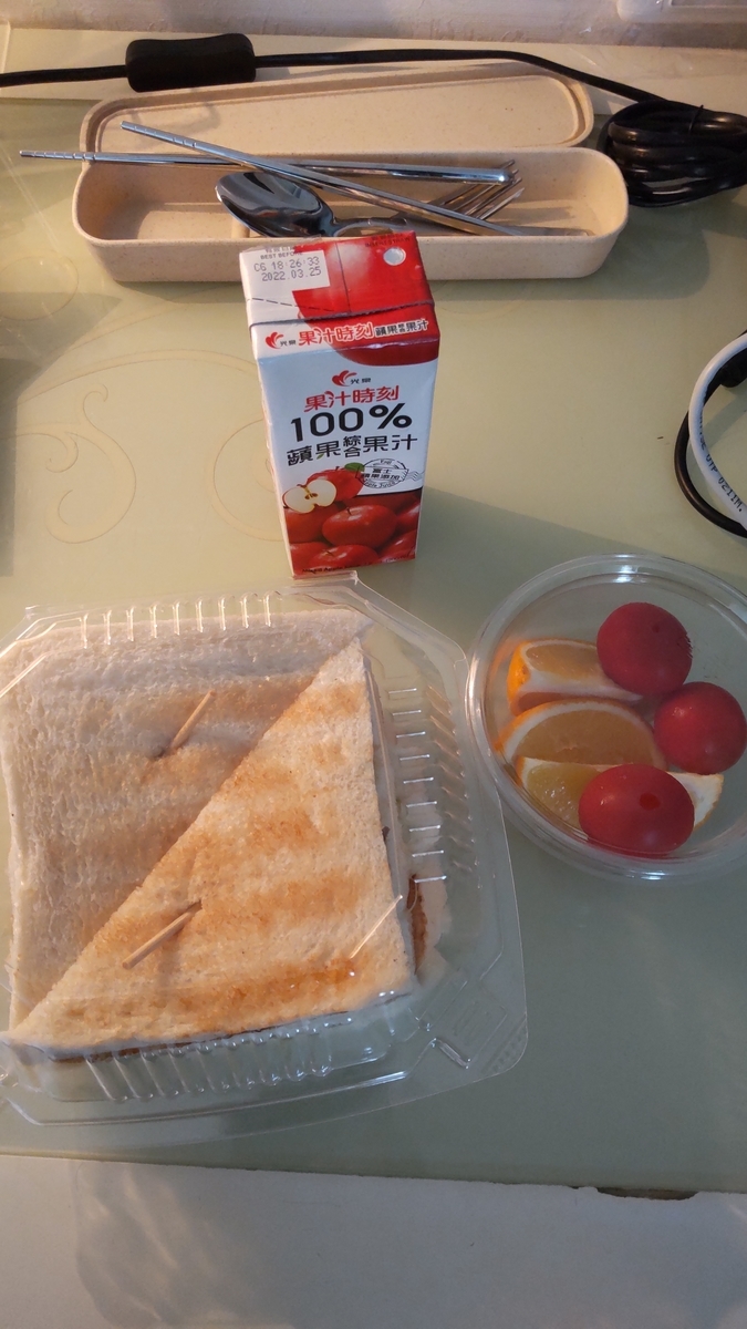10日目の朝食。シーチキンの四段サンドイッチ、トマト、オレンジ、りんごジュース