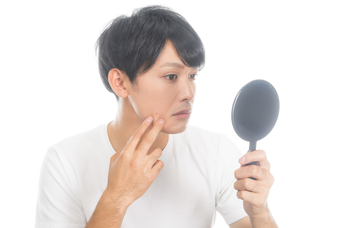 手鏡で自分の顔をチェックする男