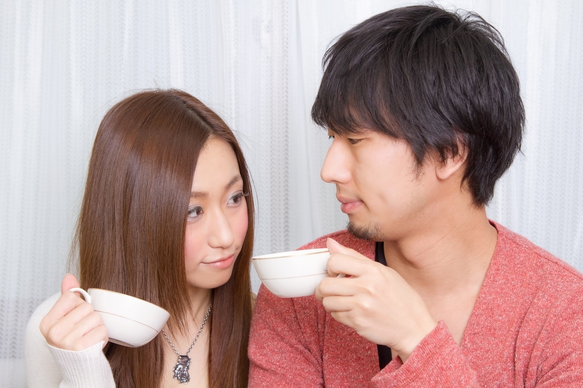 お揃いのコーヒーカップで乾杯する男女