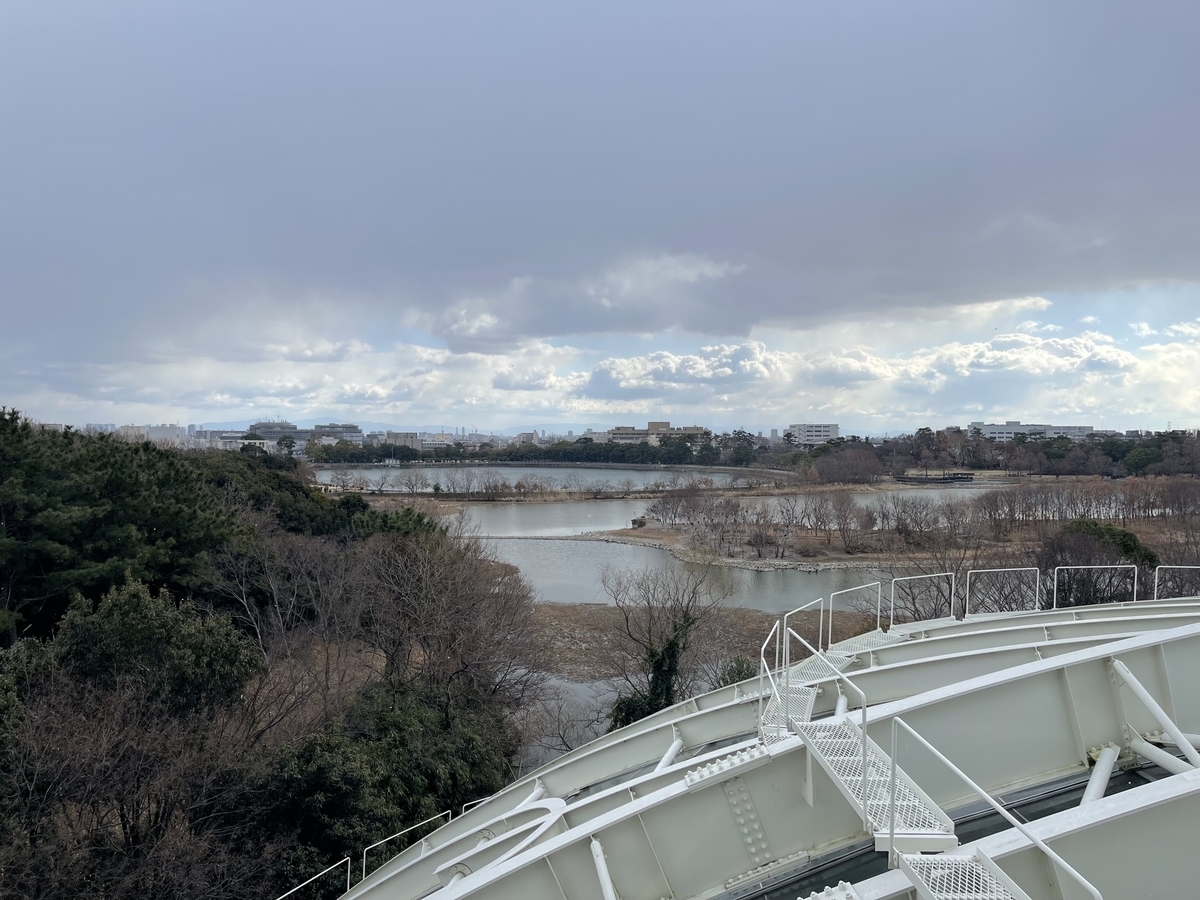 伊丹市昆虫館の屋上展望台からの眺め。大きな池が見える。雪がちらちらと舞っている。