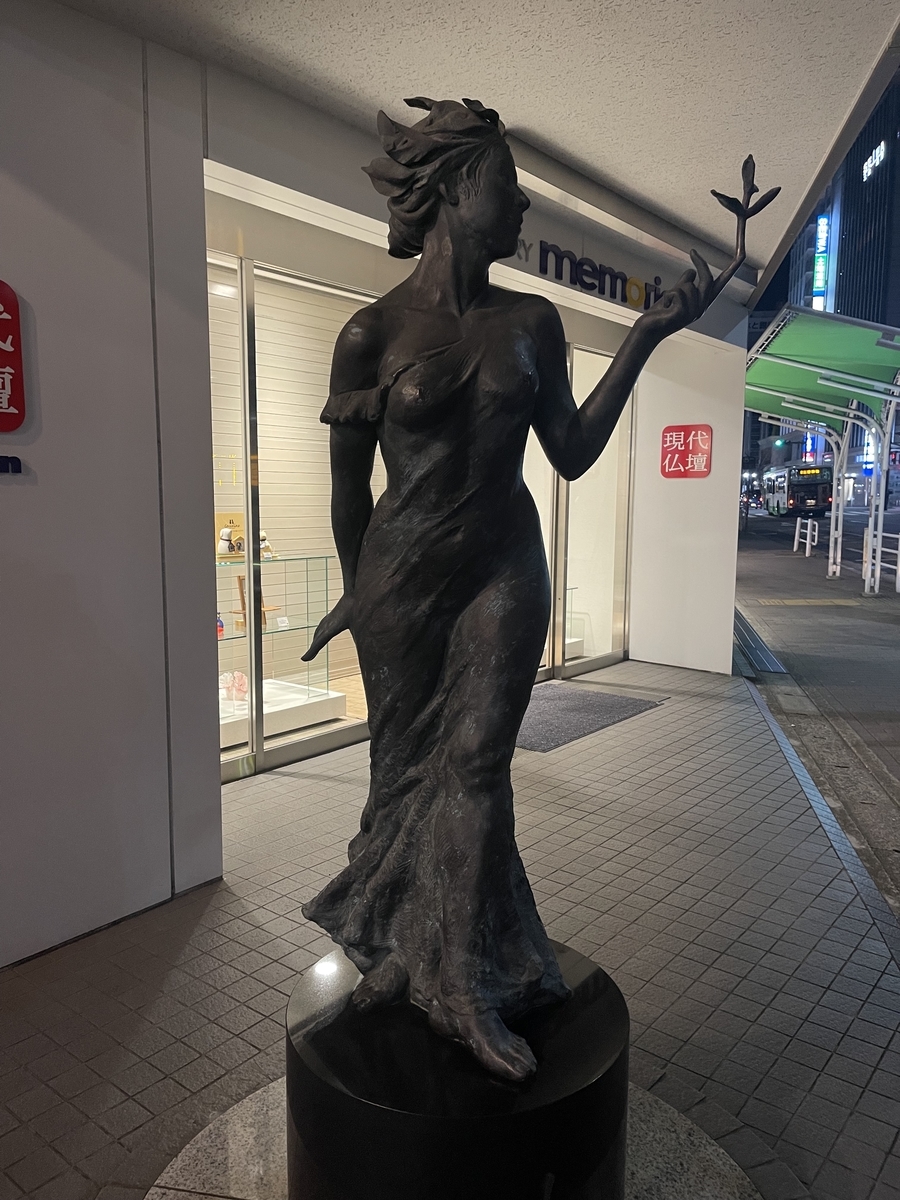 女性の立像。左手の指先から植物が芽吹いている。