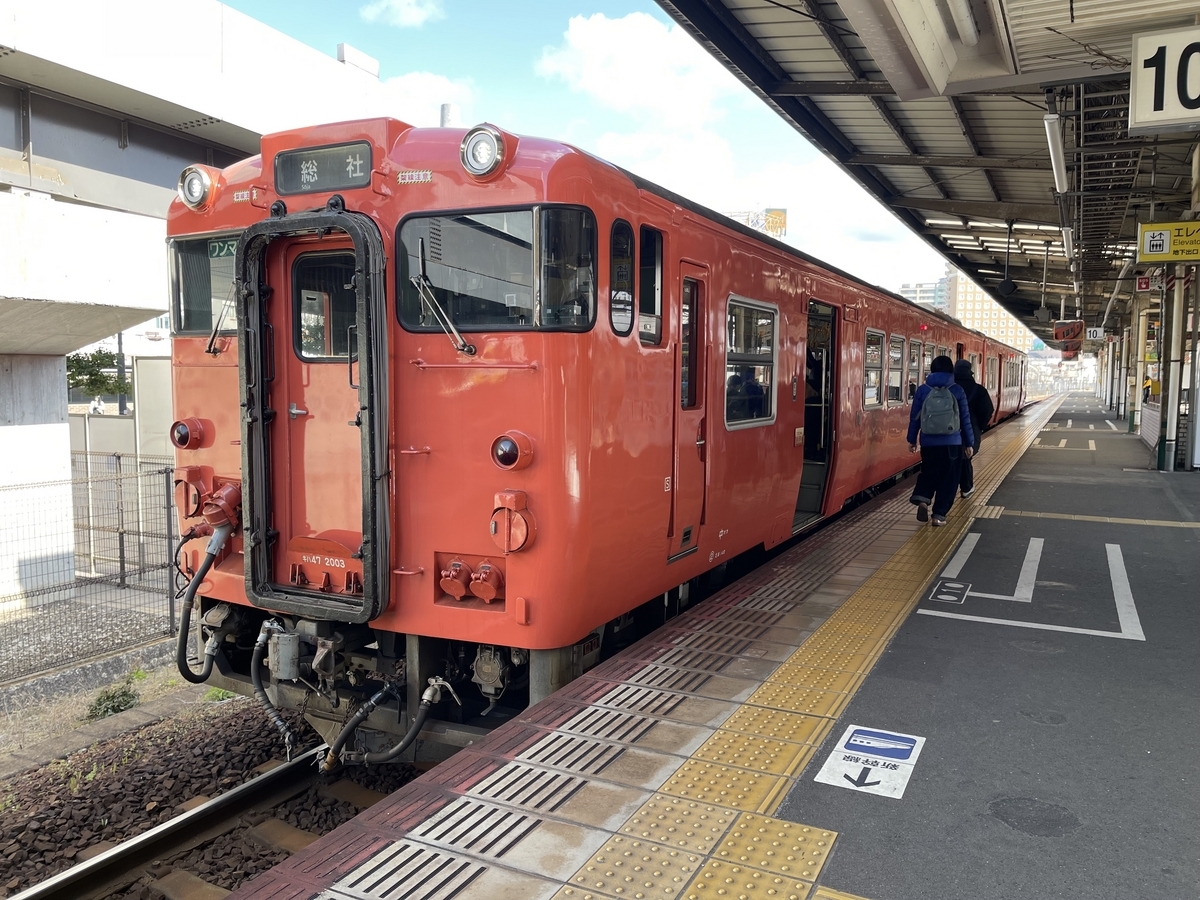 岡山駅10番ホームに停車している2両編成の桃太郎線の列車です。車体は朱色のような赤っぽい色です。