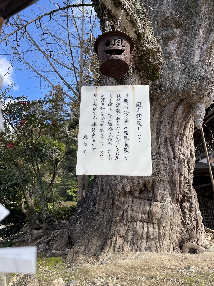 風と月の透かし彫りが施された灯籠が木にかけられています。