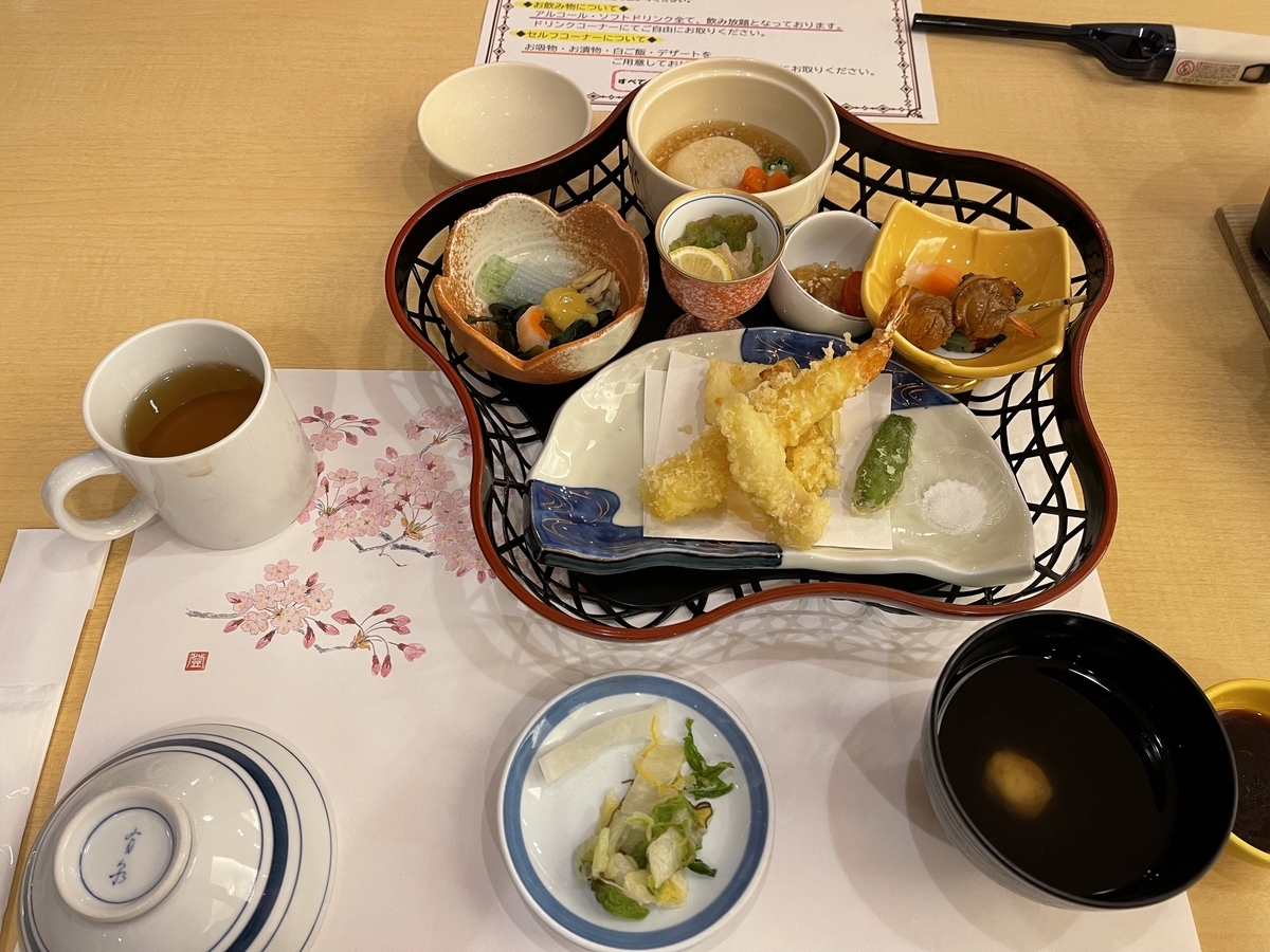 天ぷらや小鉢などが籠に盛られています。