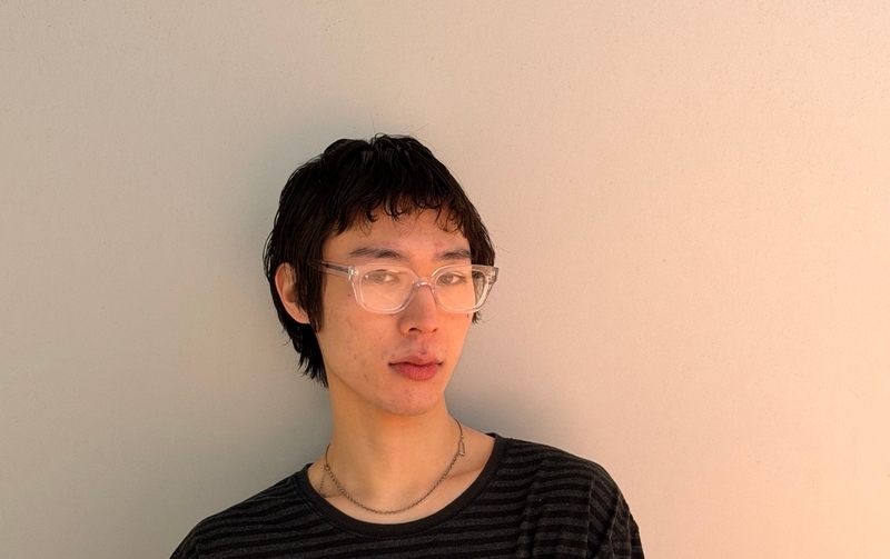 透明フレームと透明レンズをストライプ柄のトップスに合わせた着用例