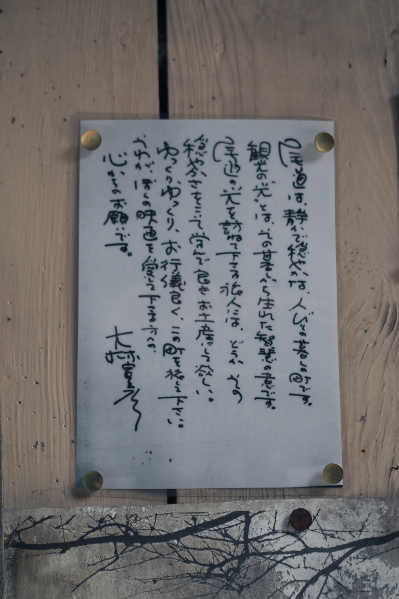 監督直筆のメッセージ（のおそらく縮小コピー）がラミネートされて民家の壁に貼ってある。