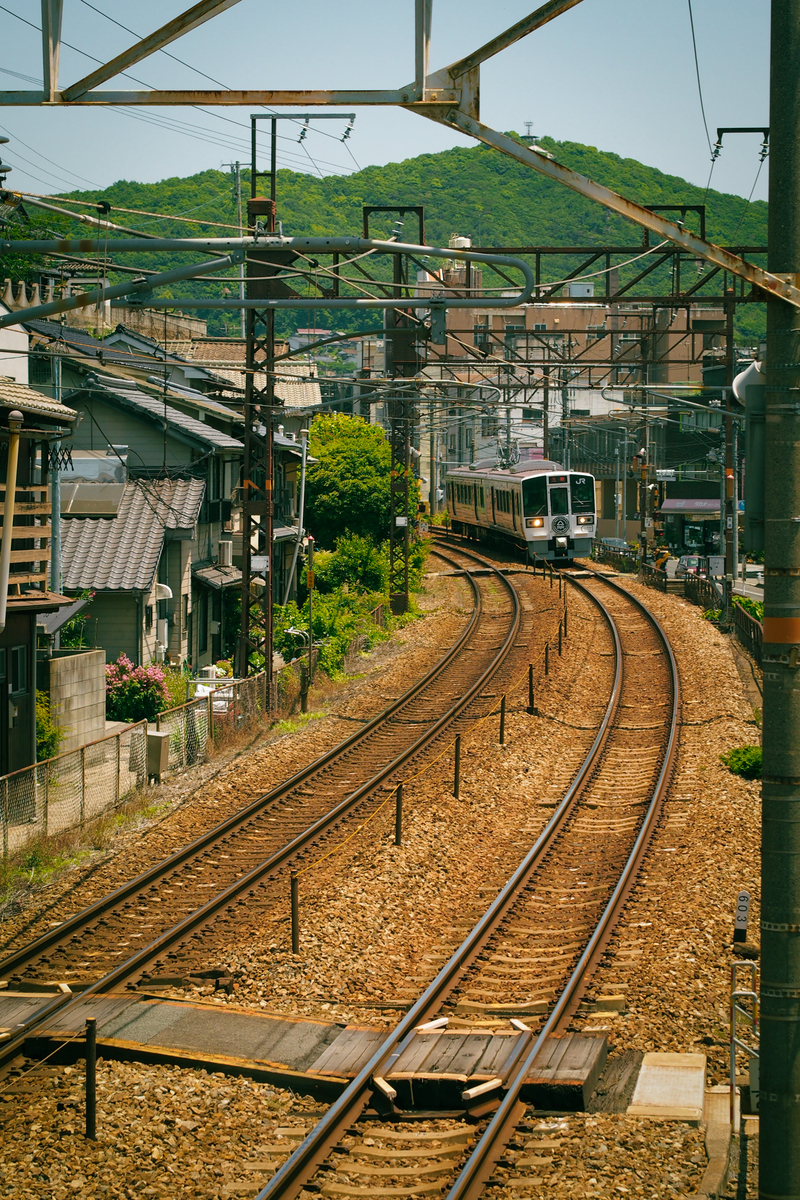 味気のない車両がヘッドライトをつけてカーブの向こうから入ってくる。