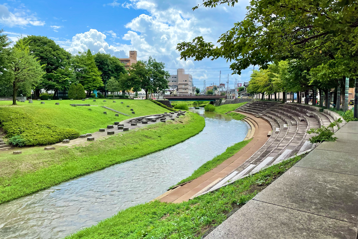 小さめの川を、緑豊かな公園と石段が挟む。