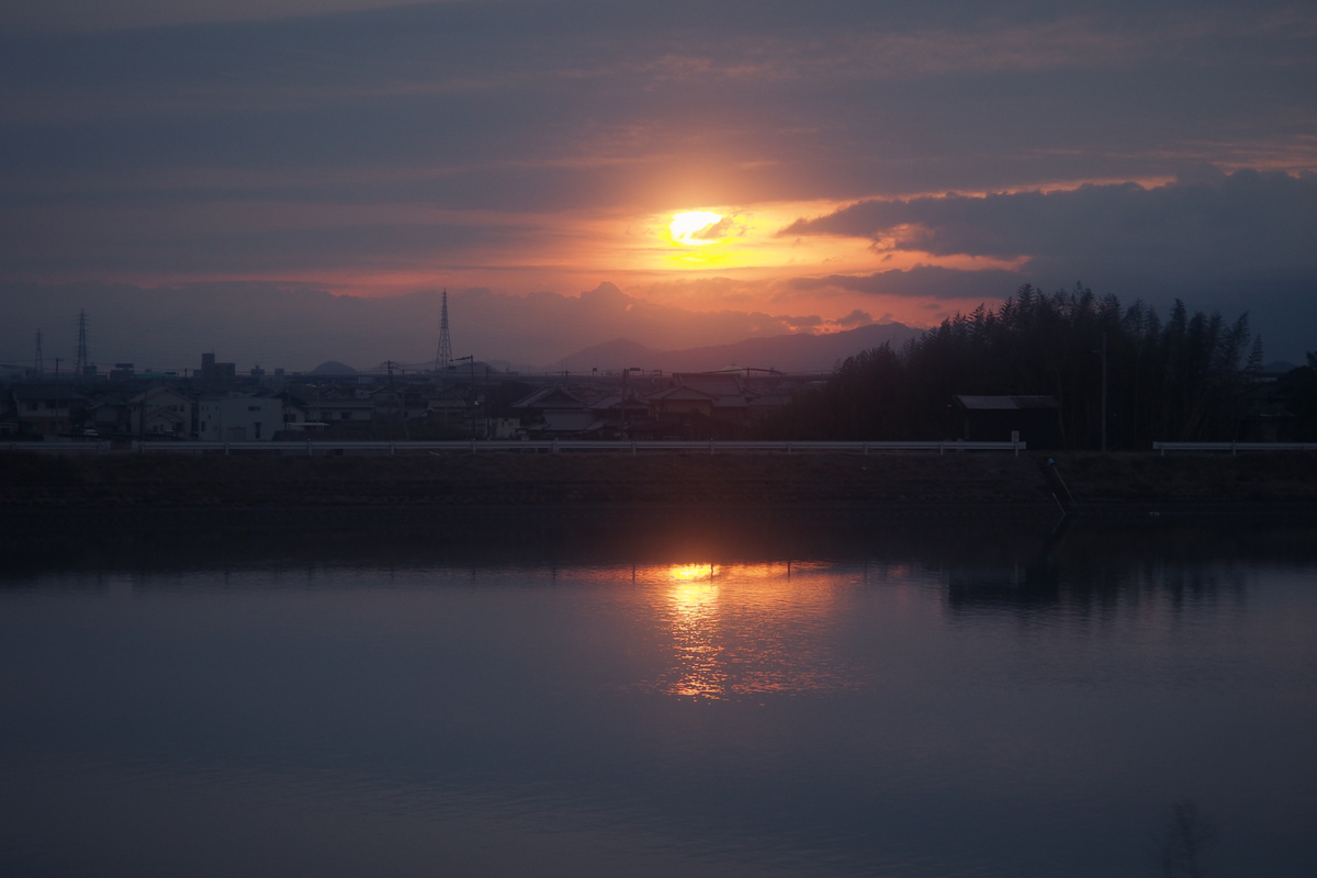 薄暗い空、眩しい朝日、水面に反射する光。