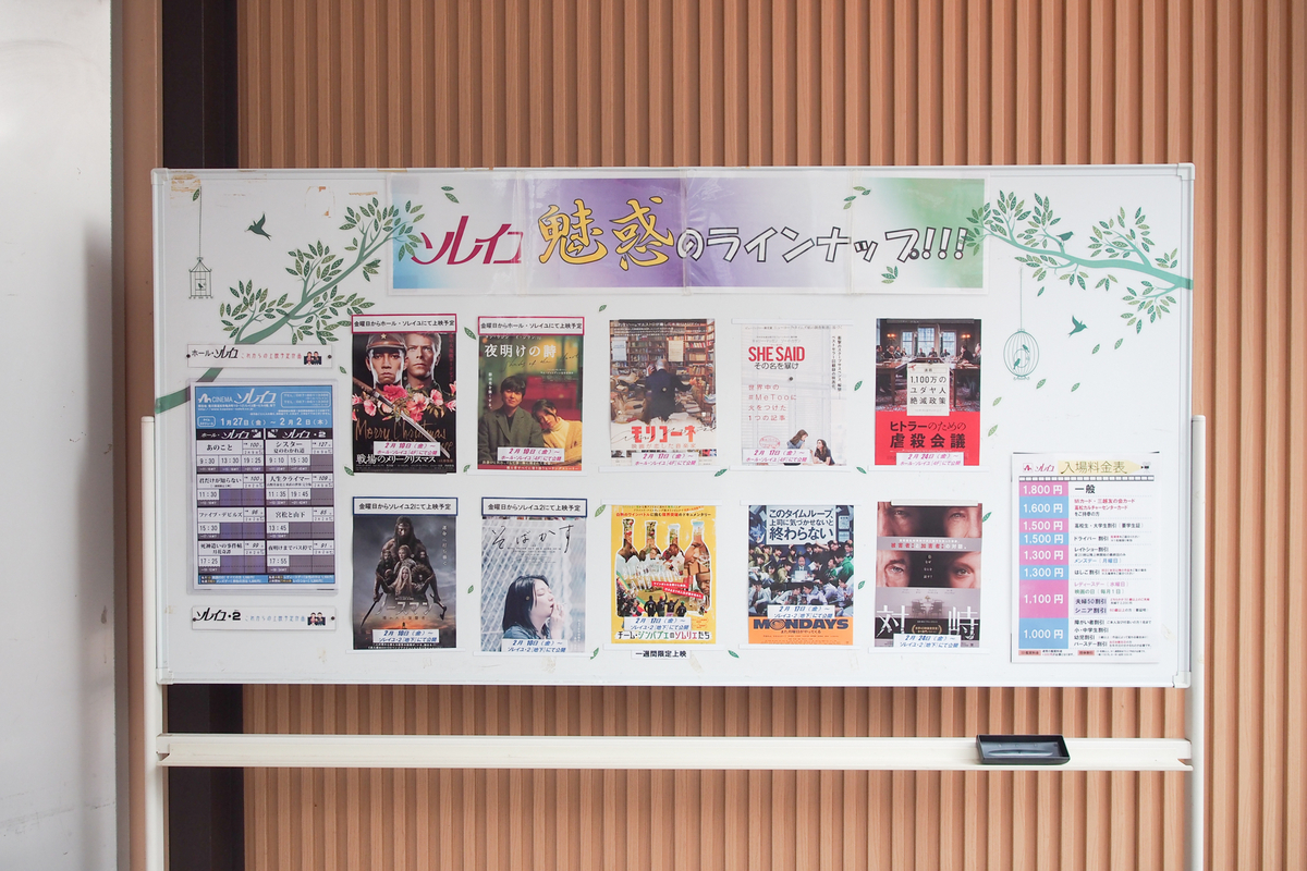 ラインナップのポスターが貼られたホワイトボード