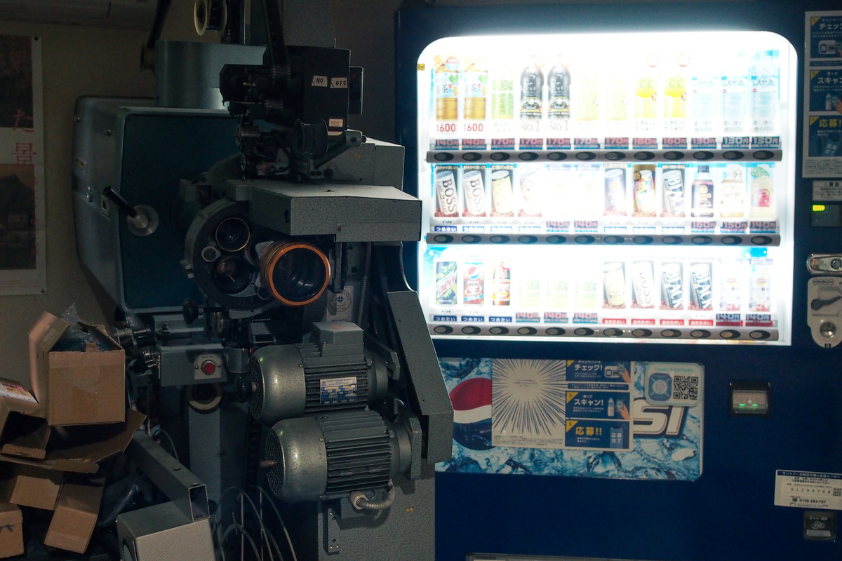 奥まった場所にある自販機と、その手前になぜか映写機。