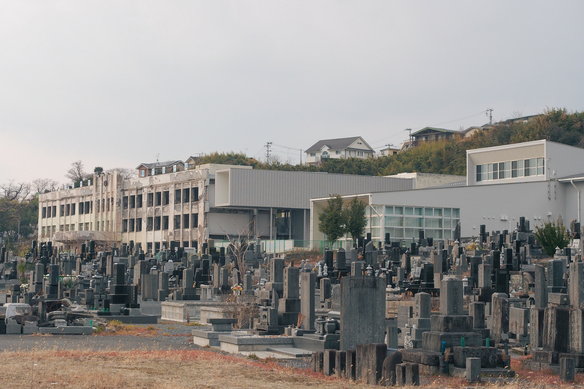 焦げた校舎の手前に、大量の墓石。