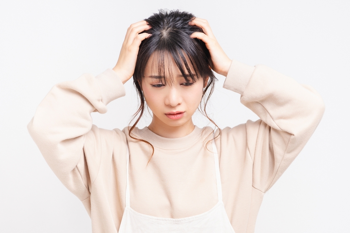 女性が頭を抱えている