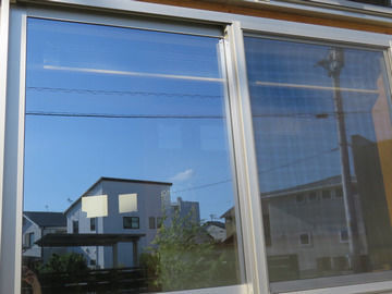 空が写り込んだ窓の画像