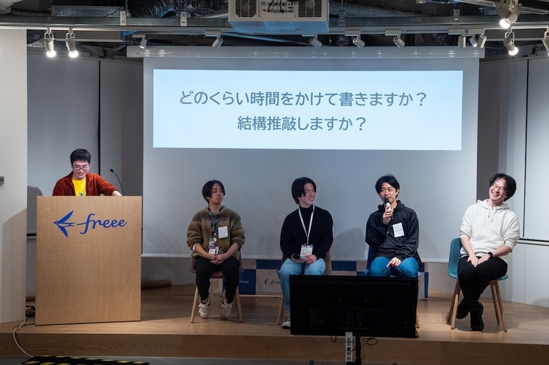 パネルディスカッションの様子。ステージ上に左から司会、登壇者(izumin5210さん、おおいしさん、lacolacoさん、berlysiaさん)が並んでいる。