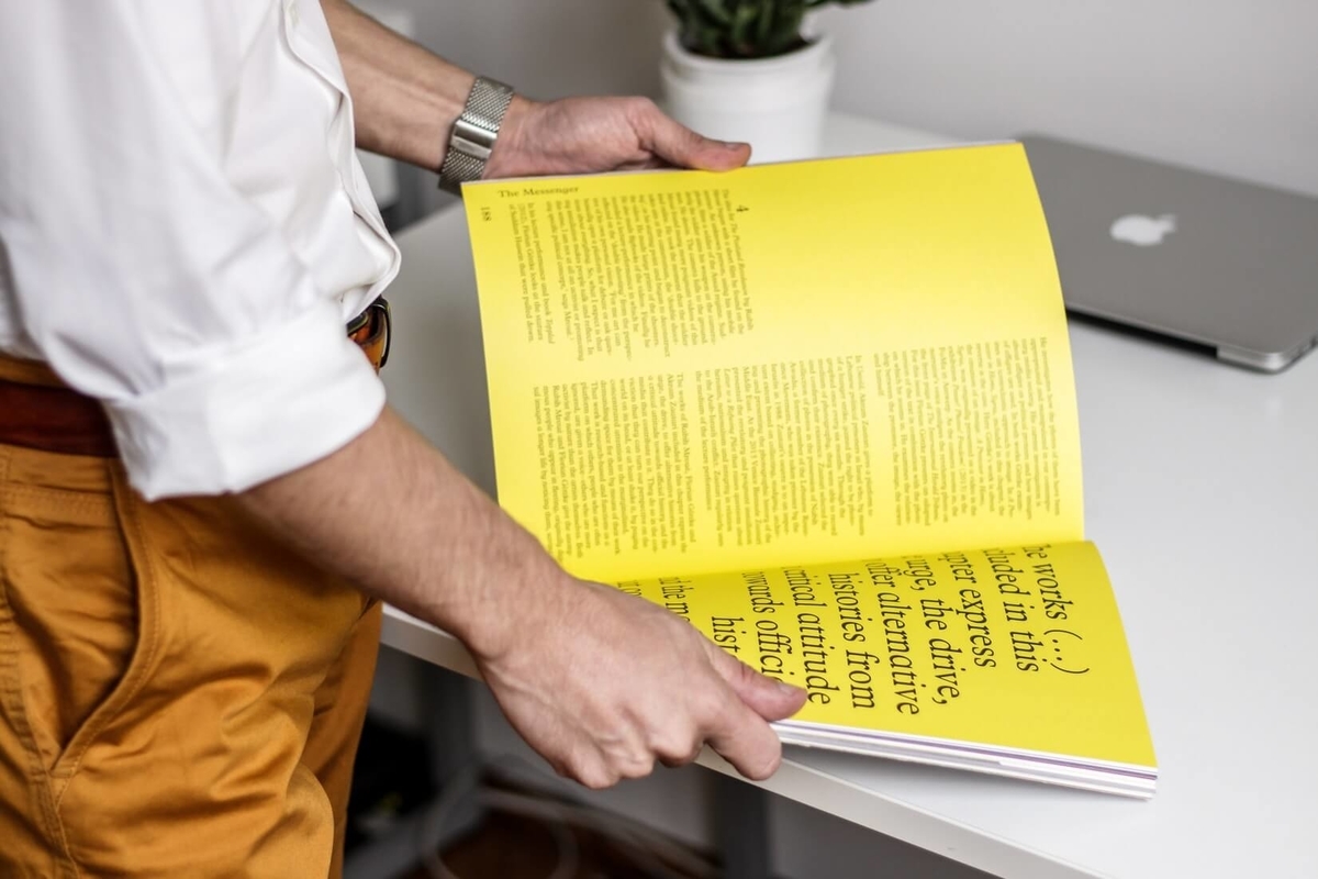 立ちながら読書をする男性