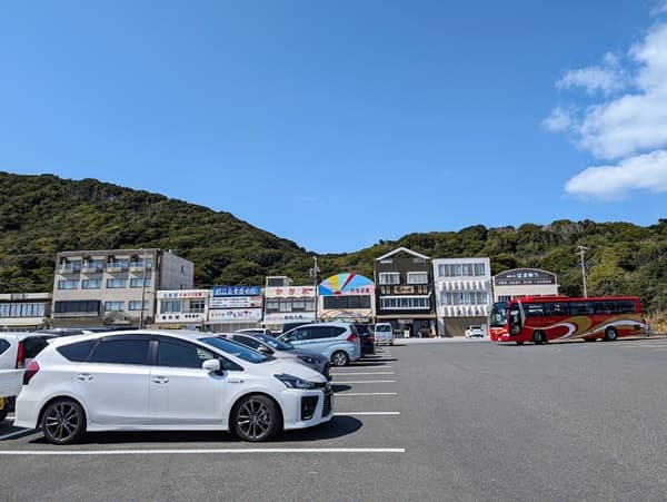 数台の車の向こうに建つ店