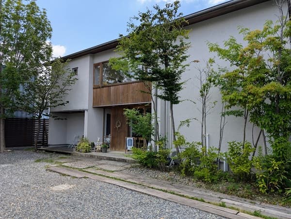 白い外壁の建物の前に３本の木