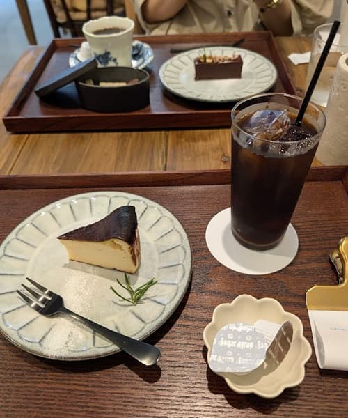 木のテーブルと白い皿とケーキと飲み物