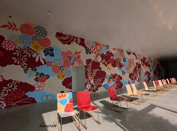 金沢２１世紀美術館の館内に置かれているカラフルな椅子と壁一面に描かれたカラフルな花