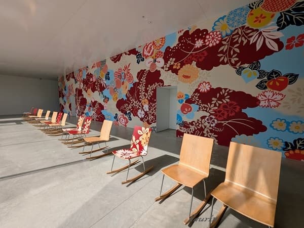 金沢２１世紀美術館の館内に置かれているカラフルな椅子と壁一面に描かれたカラフルな花