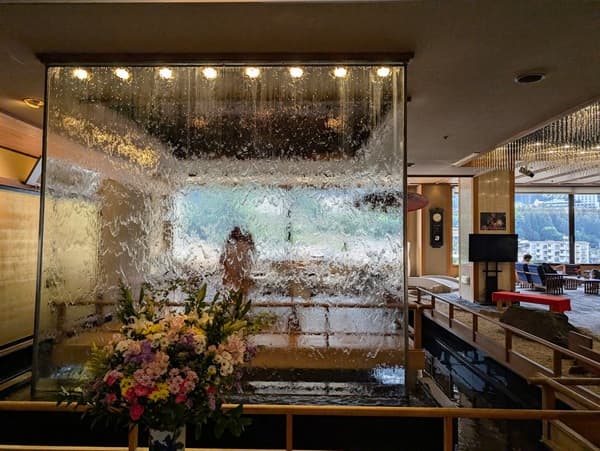 温泉宿の入口から入った景色で水が流れる衝立がある