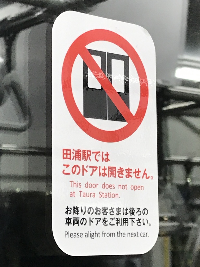 E235系1号車ドアに貼られた、田浦駅でドア開かない掲示(2020/12/21)