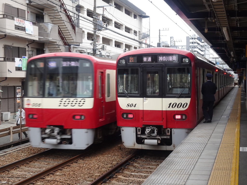 生麦駅1番線を通過する1001編成エアポート急行逗子・葉山行き、2番線で待避中の1801編成普通神奈川新町行き(2021/4/4)