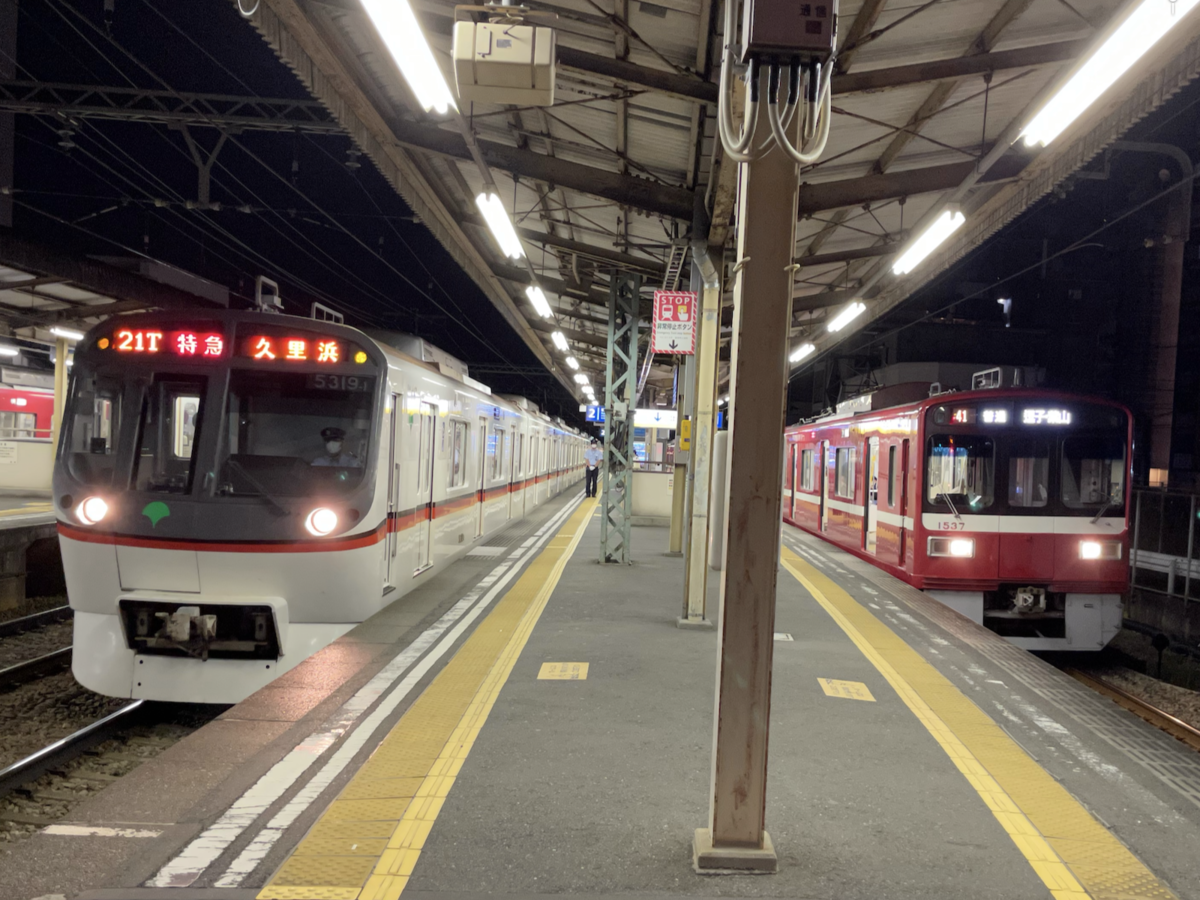 神奈川新町駅2番線に到着する特急京急久里浜行き、1番線で待避中の普通逗子・葉山行き(2021/7/18)