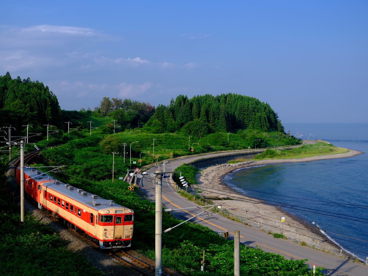 津軽海峡に沿って走る、道南いさりび鉄道の急行色とタラコ色のキハ40を