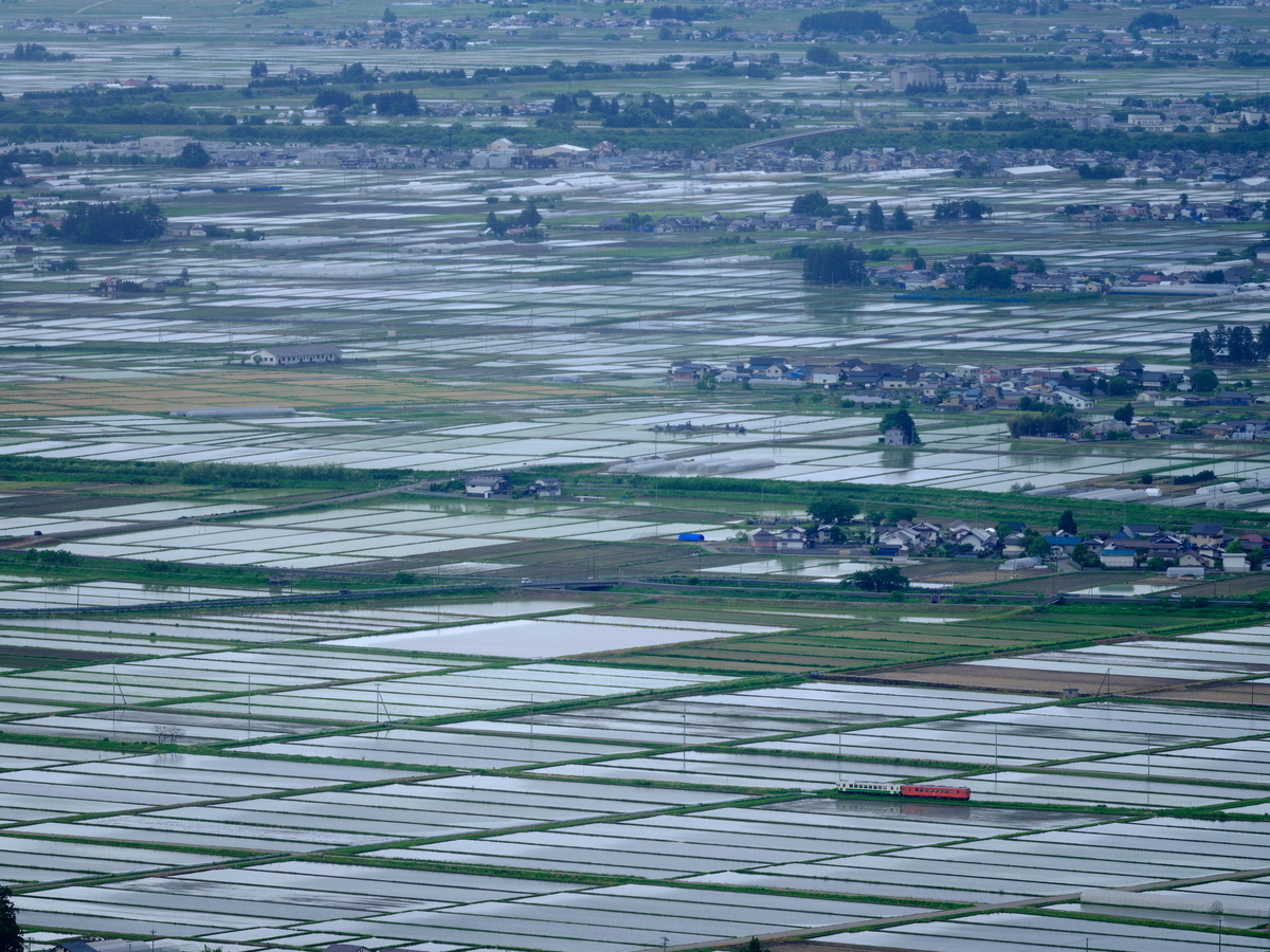 田植え直後の会津盆地を往く、タラコ色と東北地域本社色コンビのキハ