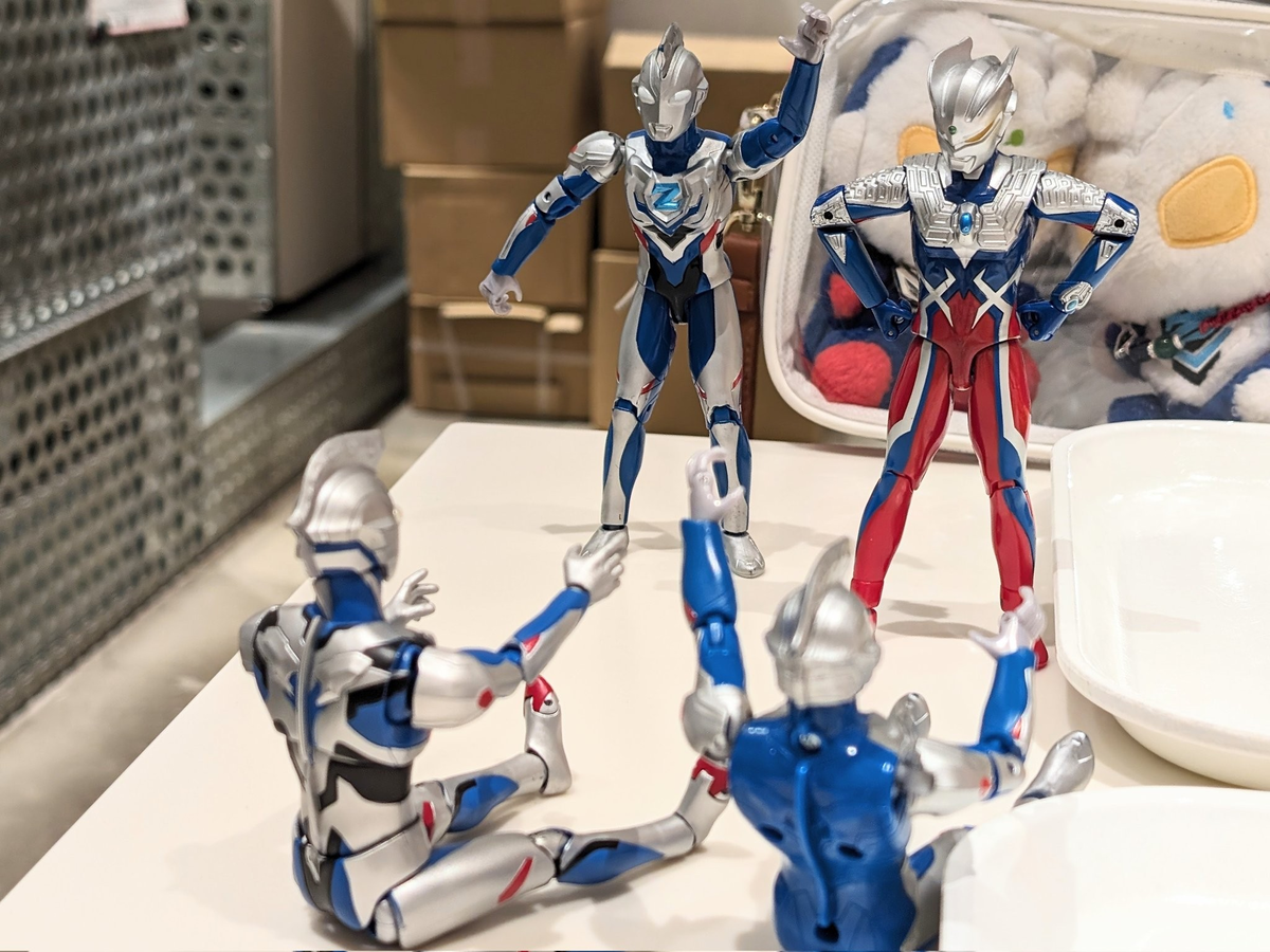 åçæåã«ã¯ããã¡ãã«èäžãåããŠè¶³ãåã«äŒžã°ããŠåº§ã£ãŠãããŒãããã¡ããŒãã¯è
°ã«æãåœãŠãŠç«ã£ãŠãããª2人ãèŠäžãããŠããããã®æšªã§ã¢ã¯ã·ã§ã³ã®ãŒãããå·ŠæããããŠç«ã£ãŠãããèåŸã«ã¯ããŒãã«å
¥ã£ããŒããšãŒããã®ã¬ãããã¿ãåã£ãŠããã