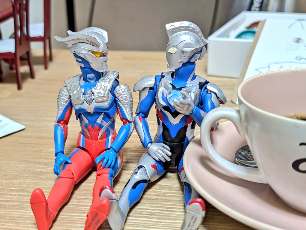 ã¢ãŒãã®ãŒããšãŒãããã³ãŒããŒã«ããã®é£ã«äžŠãã§åº§ã£ãŠããããäºãã®é¡ãèŠãŠè©±ããŠããã