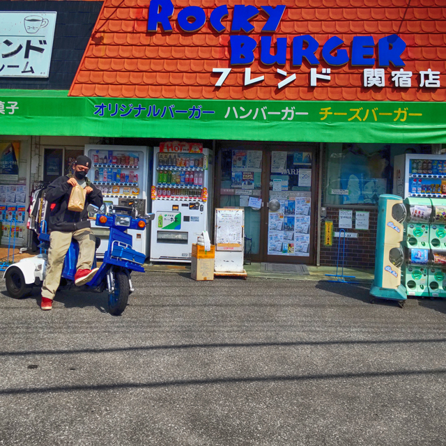 ハンバーガーが入ってる袋をのぞき込む男