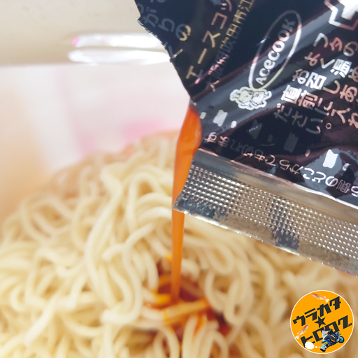 エースコックのタラタラしてんじゃね~よ焼きそばに添付のソースをかけている様子、色が赤いソースはまるでラー油のよう