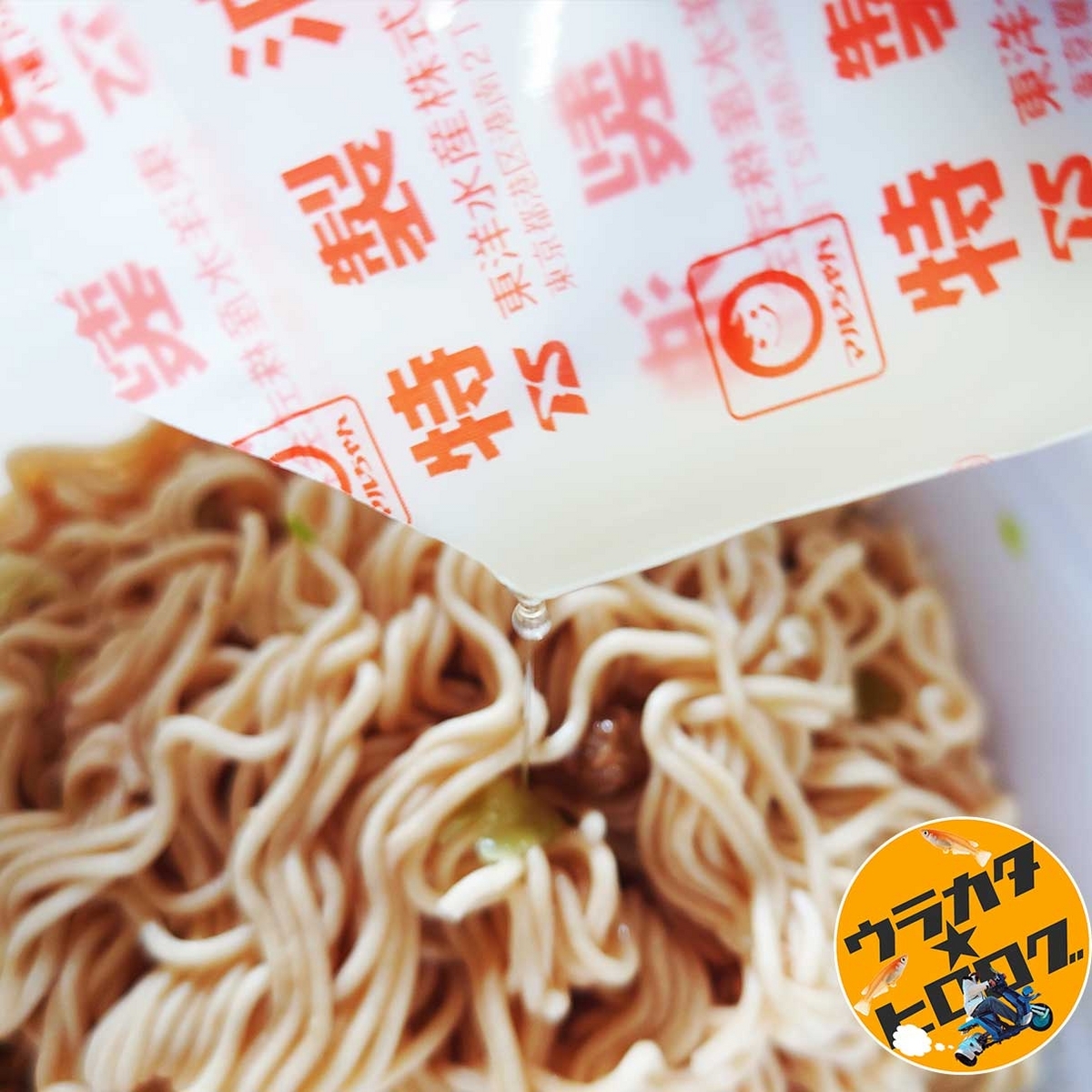 マルちゃん焼そば(インスタント版)に付属している特製油を茹であがった麺にかけている様子の写真